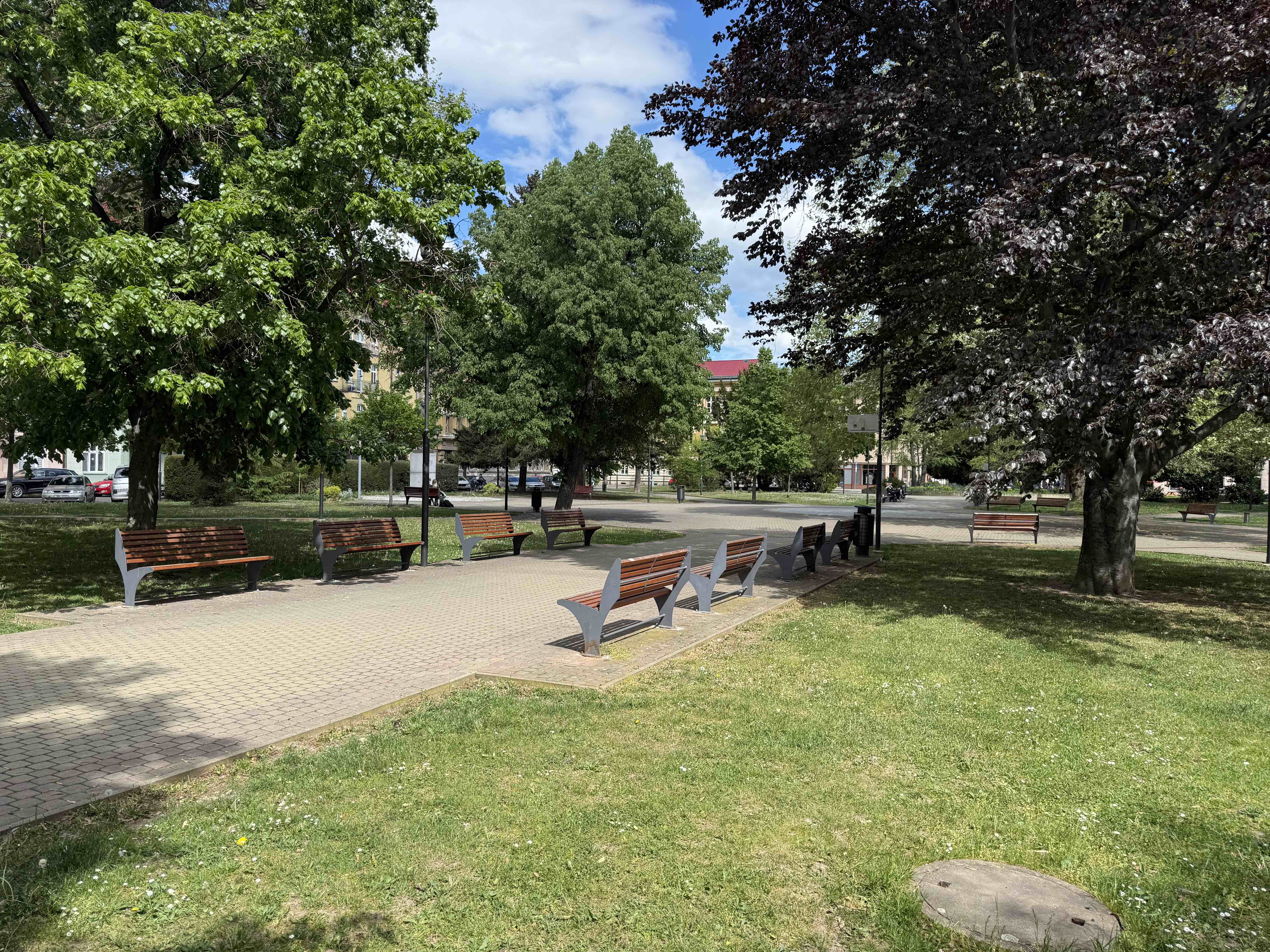 Park u ubytovny — lavičky a stromy